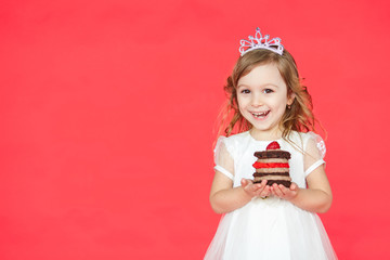 Happy little girl with birthday cake isolated on red background