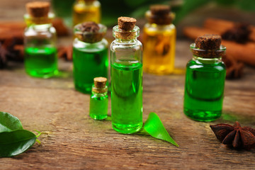 Bottles of tea oil on wooden background