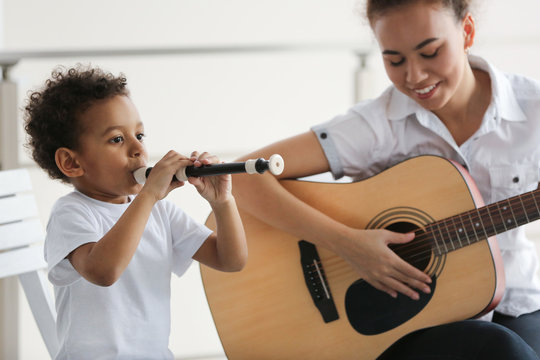 Young girl and little boy playing on music instruments