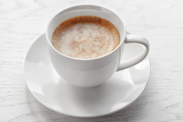 Cup of coffee on light wooden background