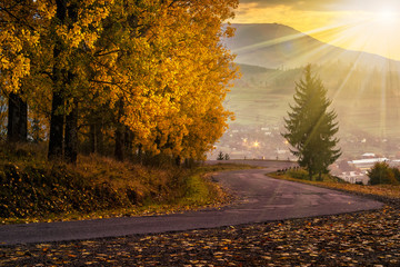 mountain road to village in mountains at sunset