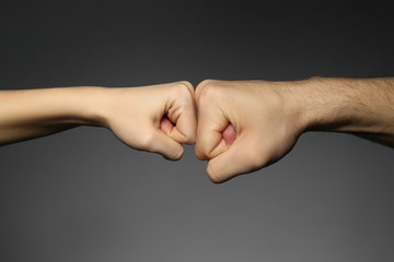 Man and woman fists on grey background