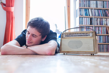 Junger Mann hört Musik mit altem Radio