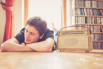 Junger Mann hört Musik mit altem Radio