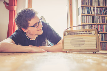 Junger Mann hört Musik mit altem Radio