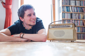 Junger Mann hört Musik mit altem Radio