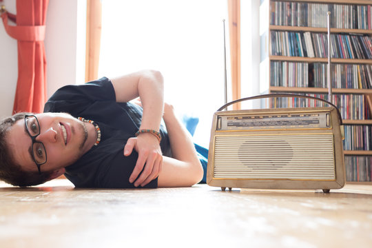 Junger Mann hört Musik mit altem Radio