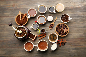 Assorted fresh coffee with spices on wooden table, top view