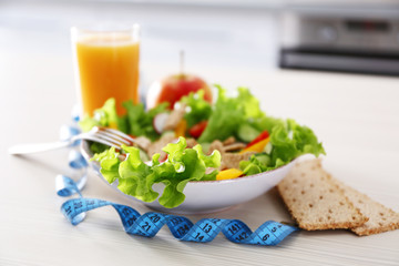 Fresh vegetarian salad and glass of juice on wooden table closeup