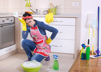 Tired and depressed cleaning lady in kitchen