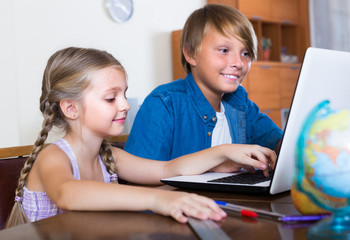 Children playing online on laptop.