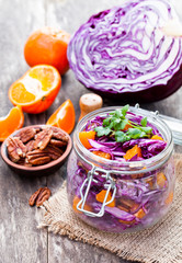 Fototapeta na wymiar healthy fresh salad with red cabbage and oranges with walnuts i