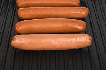cooking sausages on a black grill