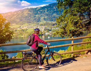 woman with e-bike cycling beside a beautiful lake-lake and bike