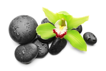 Spa stones and green orchid isolated on white