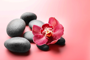 Spa stones and red orchid on pink background