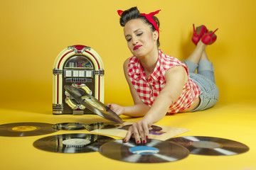Portrait beautiful pin up listening to music on an old jukebox r
