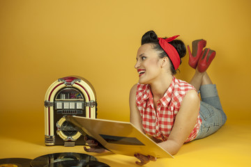 Portrait beautiful pin up listening to music on an old jukebox r