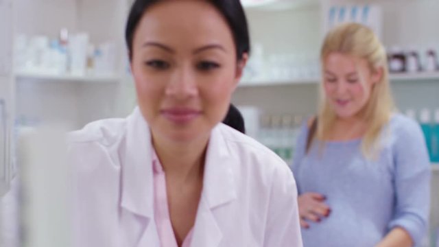  Worker in a chemist shop serving a pregnant lady