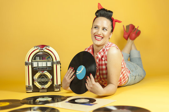 Portrait beautiful pin up listening to music on an old jukebox r