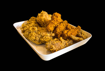 Chicken fried in a tray isolated on black background.