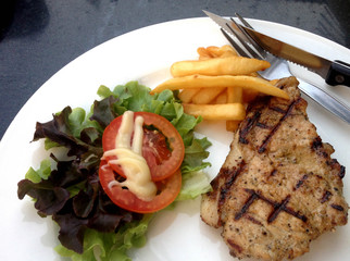 Tasty grilled pork steak with salad