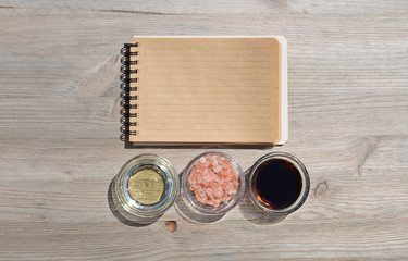 Food background. Blank open notebook for notes,salt,oil and sauce on a wooden table