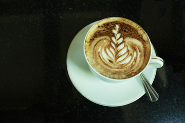 Hot coffee in white cup and saucer with silver spoon on wooden table / Hot coffee in white cup and saucer