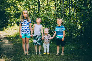 Four amicable children: One girl and three boys holding hands