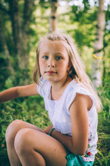 Little girl in a shirt and shorts in nature