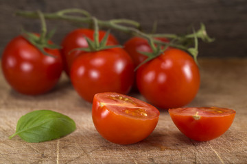 Cut in half cherry tomato with basil leaf