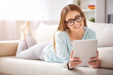 Cheerful woman lying on the couch  