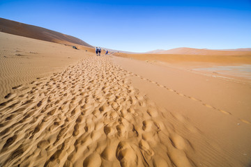Fototapeta na wymiar View of people in the red dunes of the Namib Desert, Sossusvlei