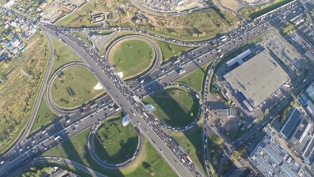 Aerial shot of transport cloverleaf interchange in the city. Rush hour and traffic jams on the roads