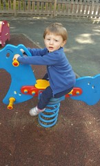 Bambino che gioca sul dondolo al parco