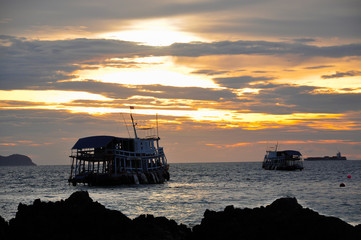 Dramatic of colorful sea and sunset sky with boats.