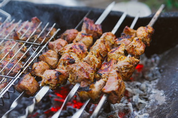 many roast meat pieces on skewer. shish kebab cooking process