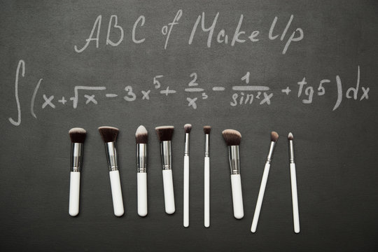 Make up brushes on black background with chulk pictures.