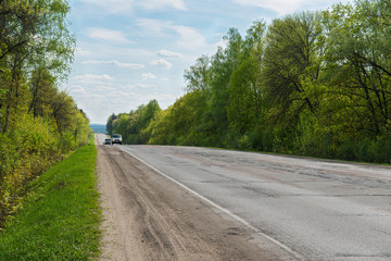 cars on the road in a wooded area