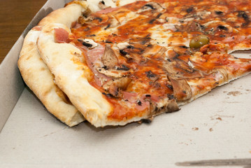 Fresh Pizza has arrived on the table and is ready to be sliced and put on plate
