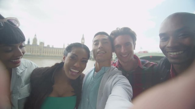  Happy mixed ethnicity friends outdoors in the city pose to take a selfie
