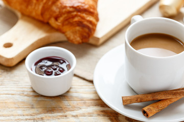 Breakfast with coffee and croissants on wooden table