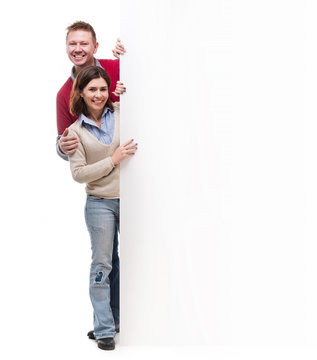 Father, Mother And Little Daughter Peek Out From Behind Empty Blank Isolated On White Background