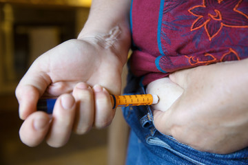 Diabetic patient injecting herself with insulin shot