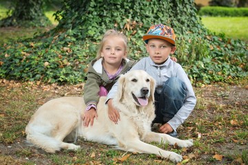 siblings with a golden retriever