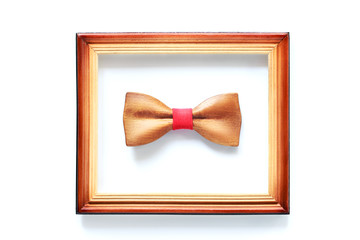 Wooden bowtie in wood frame isolated on white. Hipster, unique, initiative, think different,...