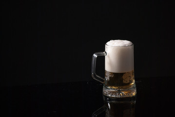 Beer glass with background and shinny reflection on bottom with beer falling into glass
