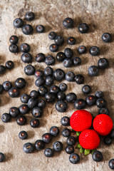blueberries and strawberries on a plate stone background