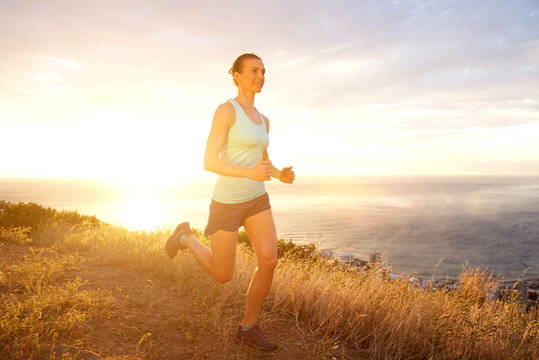 Active woman running outdoors during sunset