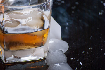 Whiskey Glass - Scotch Glass with ice cubes with background and shinny reflection on bottom